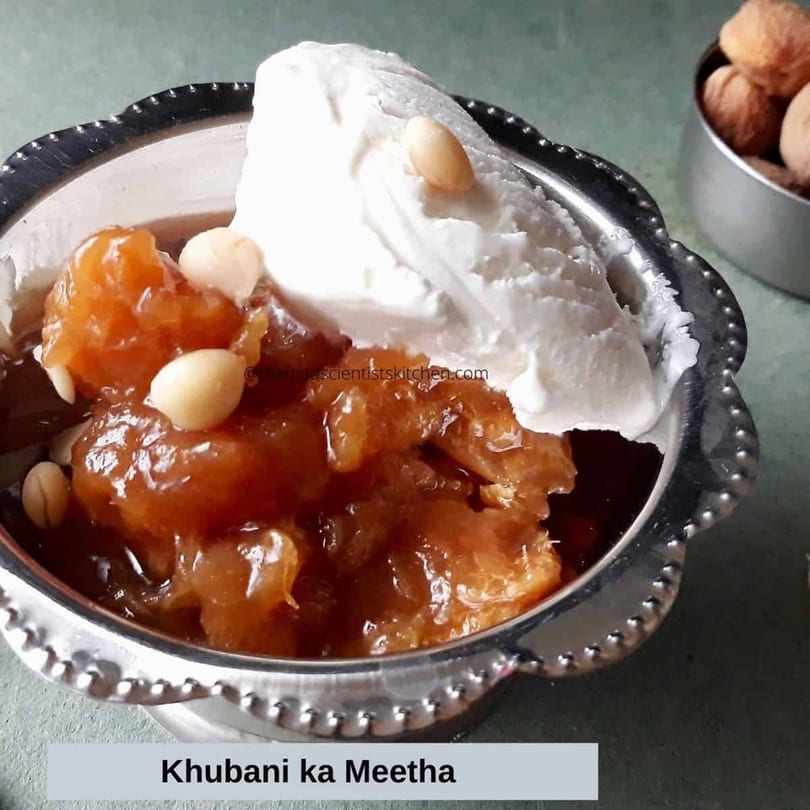 Khubani ka Meetha, an Indian apricot dessert, topped with white cream and nuts in a silver bowl.