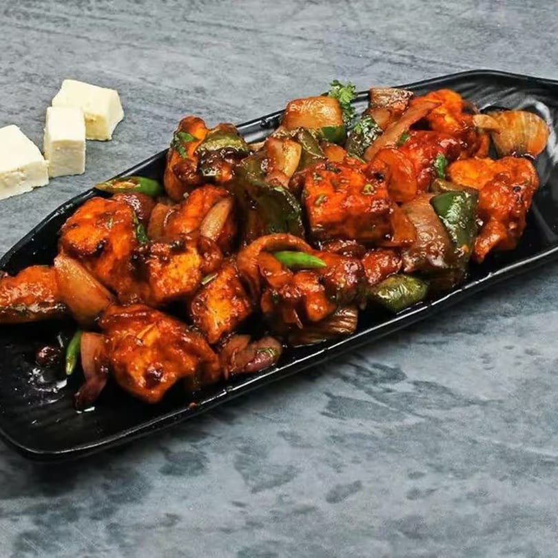 Chilli Paneer from Bawarchi Biryanis, featuring paneer, onions, and bell peppers in a rich sauce.