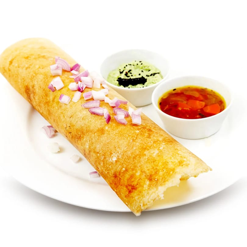 Golden dosa topped with chopped red onions, served with green and red chutneys.